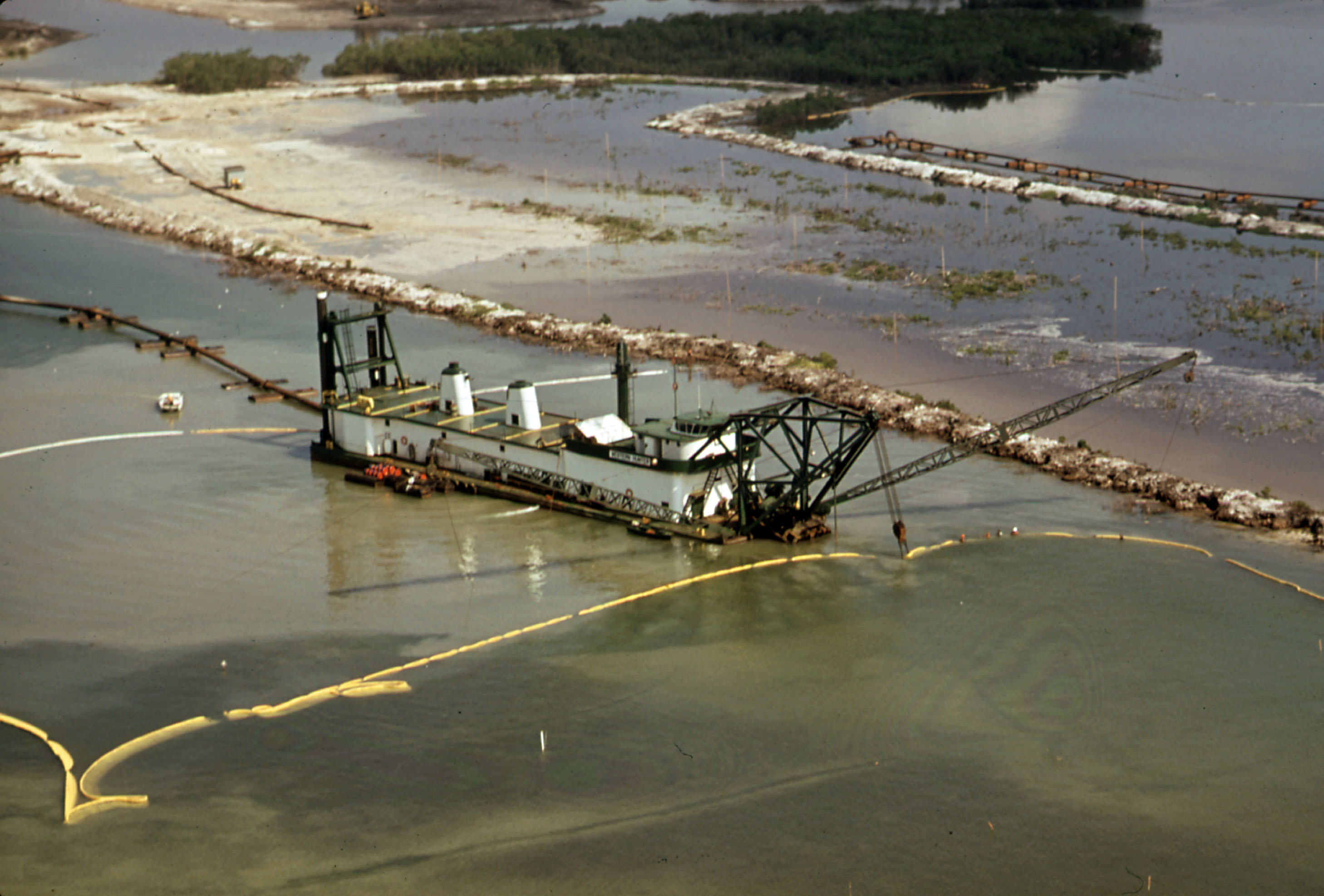 Small dredge boat in shallow water dredging earth